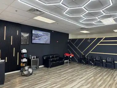 Waiting area inside NFL Cuts Barbershop in Peoria, Arizona with leather couch and TV