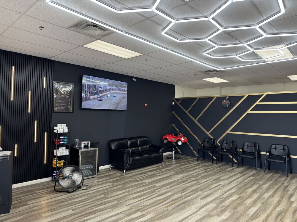 Modern waiting area with TV and seating inside NFL Cuts barbershop in Peoria, AZ