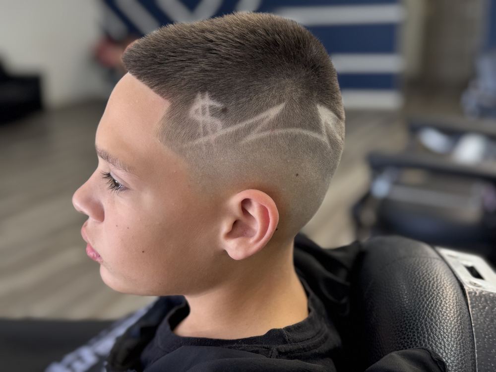 Kids haircut with a custom shaved dollar sign design at NFL Cuts in Peoria, AZ